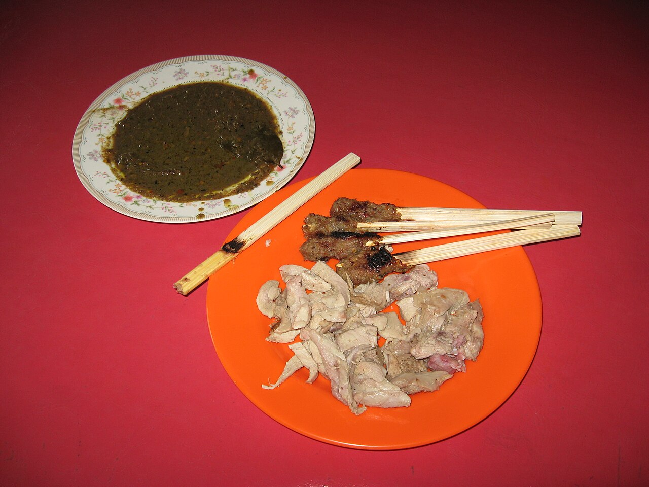 Sate lilit grilled on lemongrass sticks served with sambal matah and ayam betutu — typical dishes you'll cook in a Bali class.